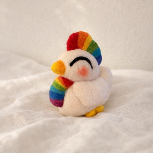Small plush toy with a rainbow design on a white surface