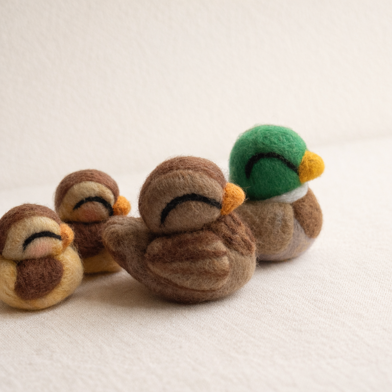 Needle felted duck family set on warm cream background