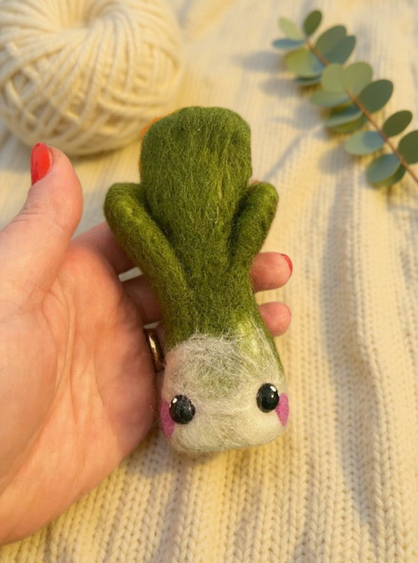 Needle felted wool leek figurine on warm cream background