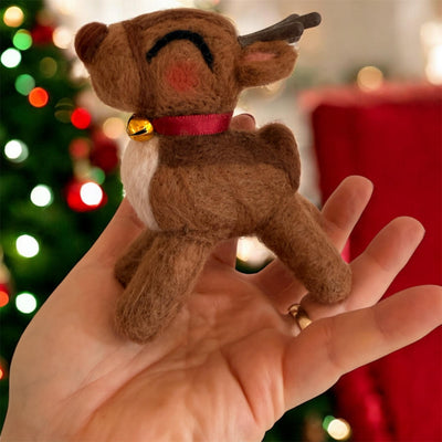 Needle felted Rudolph reindeer figurine with red nose on cream background